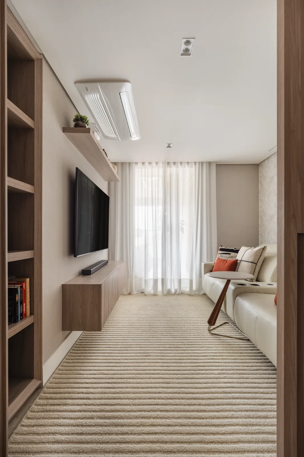 Home theater intimista com sofá de couro claro