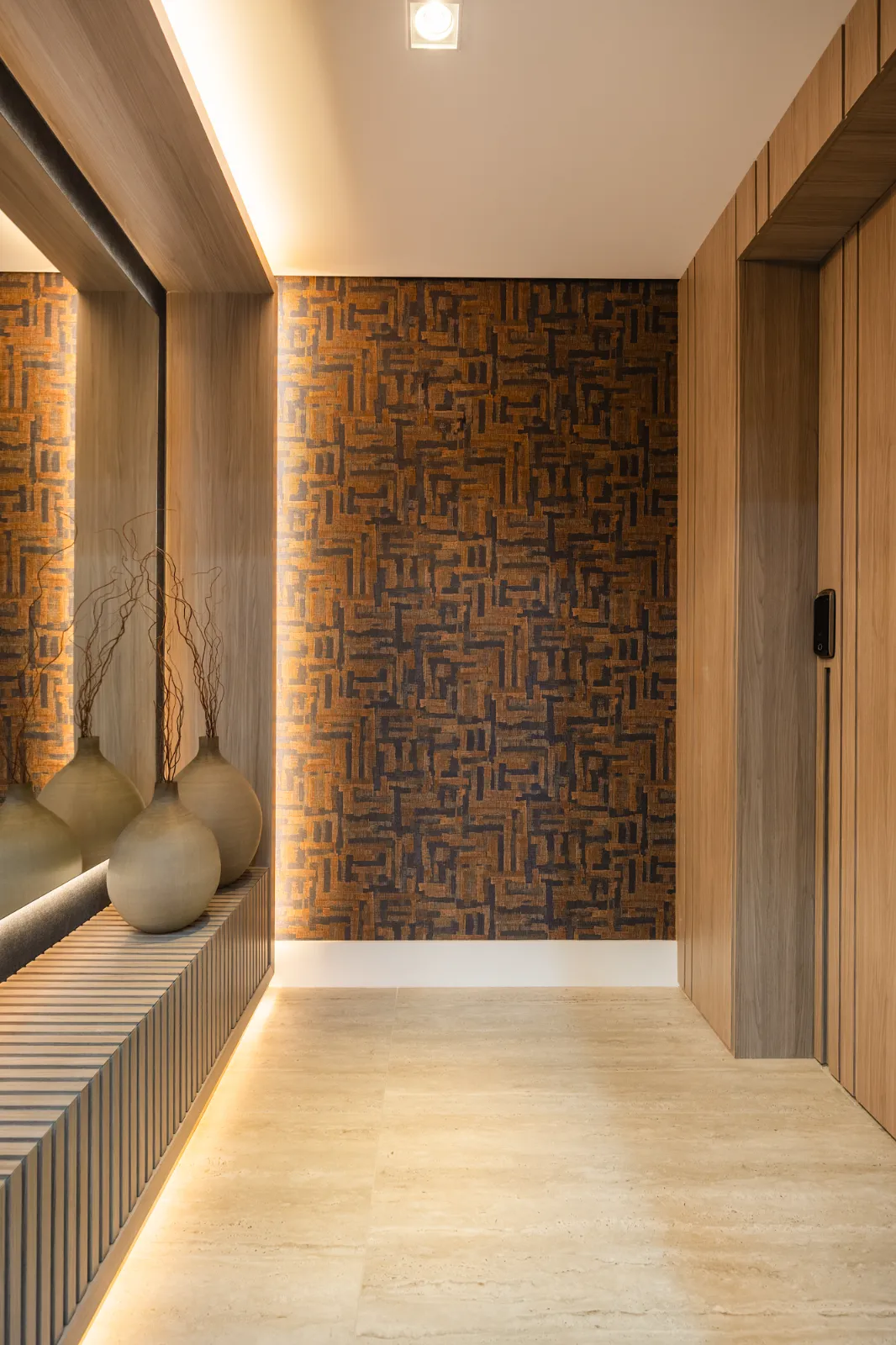 Hall com papel de parede gráfico e vasos artesanais