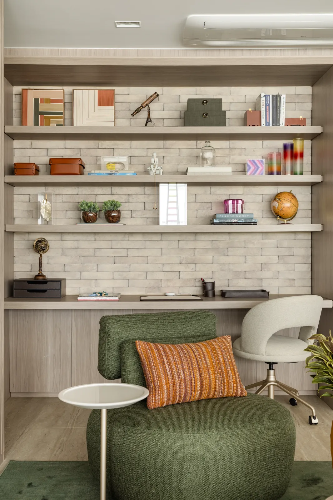 Home office com prateleiras e poltrona verde