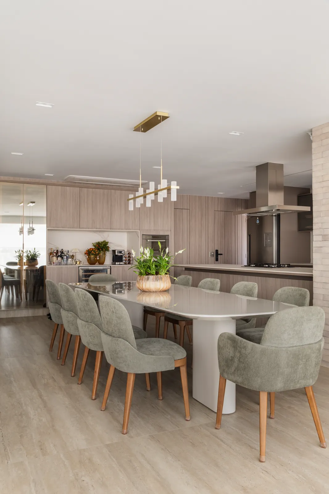 Jantar integrado à cozinha com ilha e lustre linear